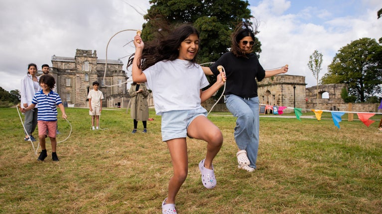 Visitors with skipping ropes on grass as part of Summer of Play at Seaton Delaval Hall, Northumberland